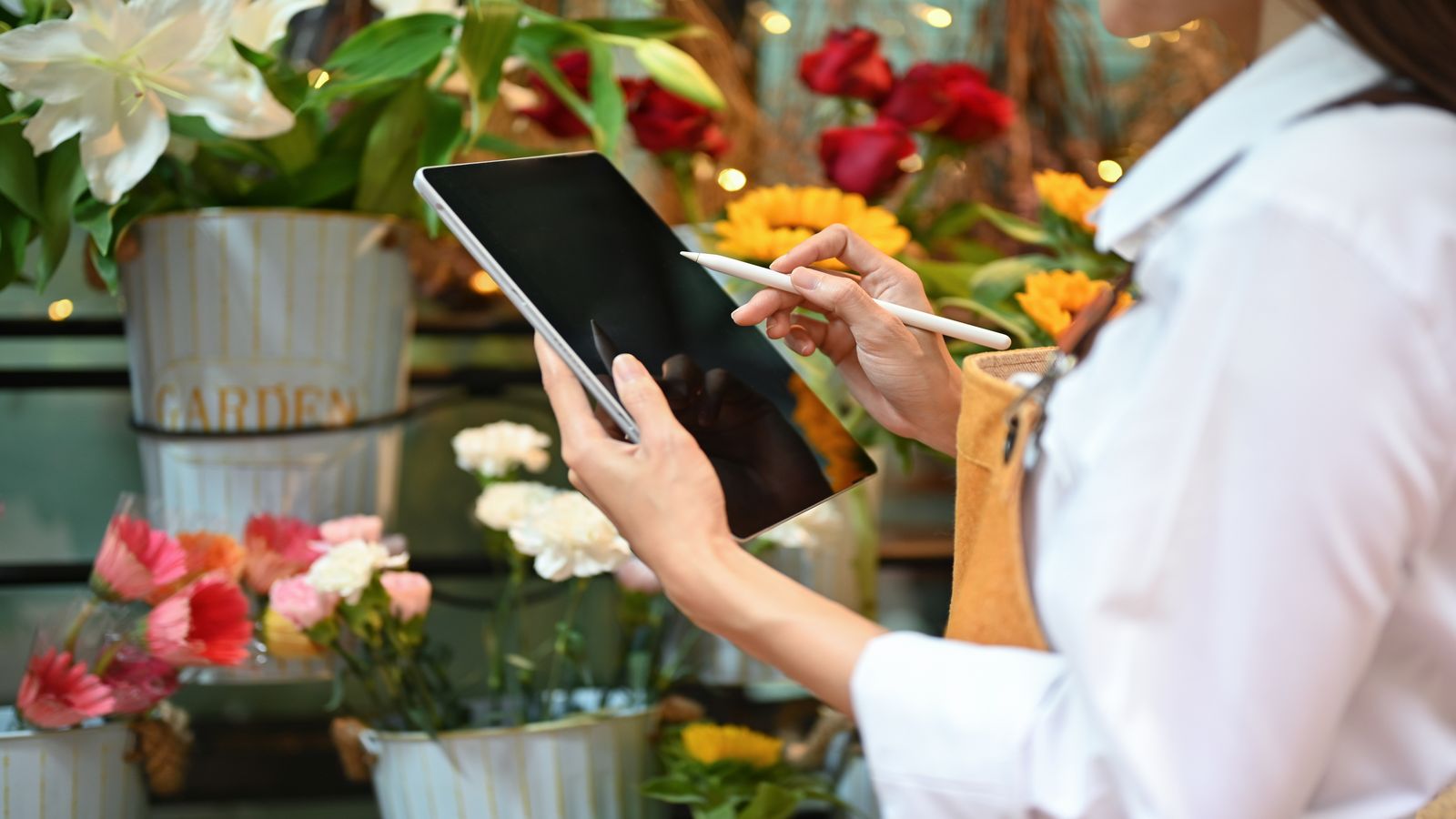 Merchant counter with a tablet showing an invoice alongside packaged flower orders