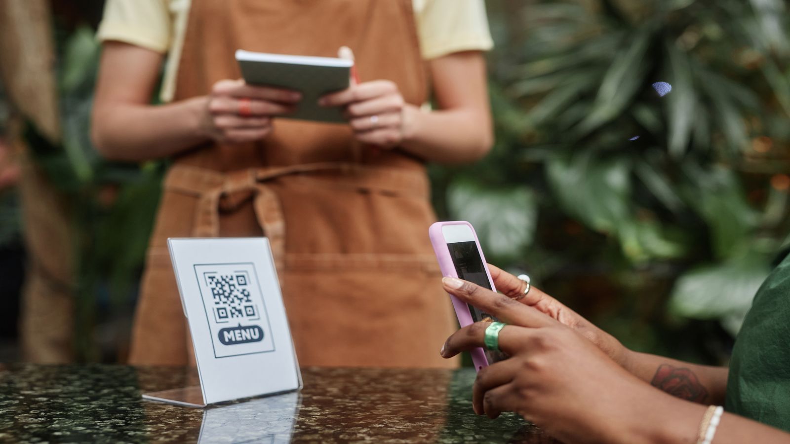 Customer and merchant at a counter, phone screen showing a Lightning payment QR code